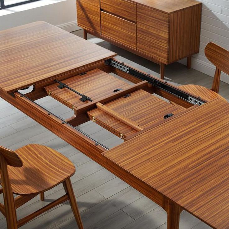 a wooden table with two chairs next to it and an open drawer in the middle