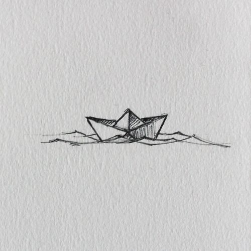 an origami boat floating in the water on top of a white sheet of paper