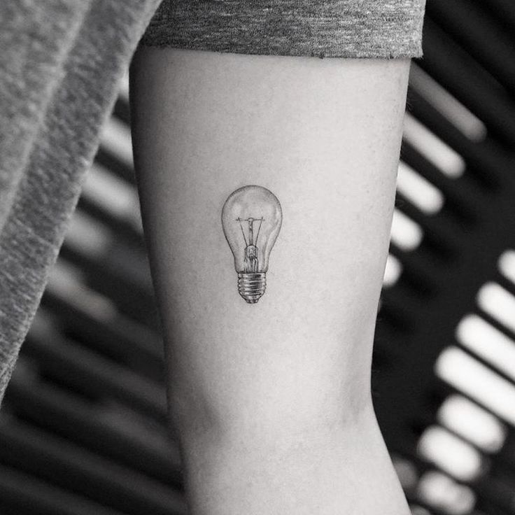 a small light bulb tattoo on the arm