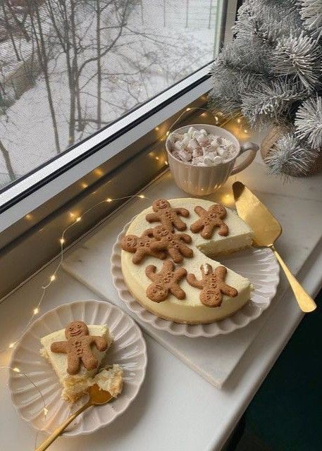 two plates with cookies on them next to a window sill and a cup filled with marshmallows