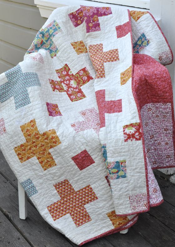 a quilted blanket sitting on top of a wooden bench