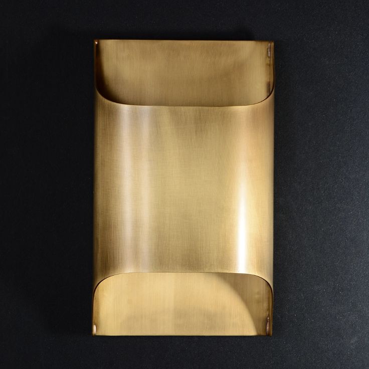 a gold metal object on a black surface