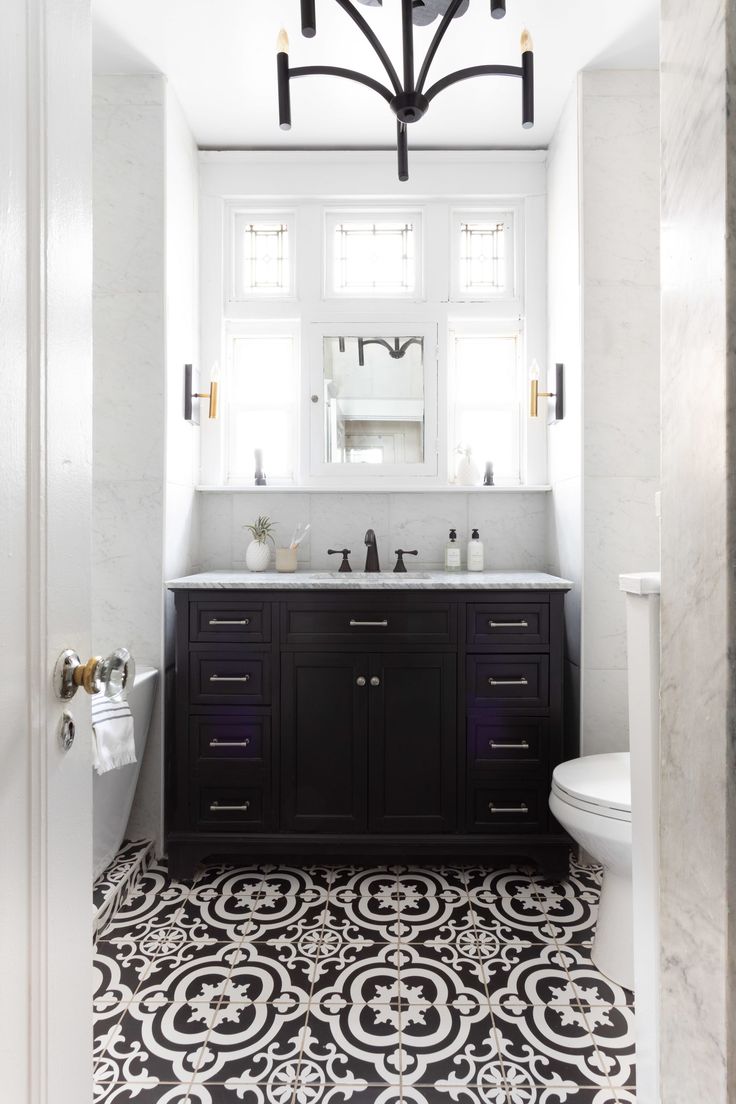 a bathroom with black and white tile flooring