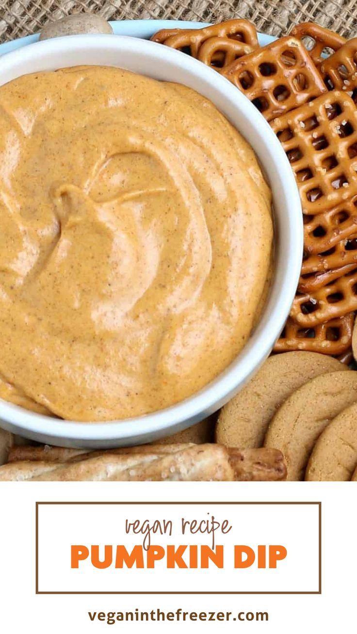 a bowl of pumpkin dip surrounded by pretzels and cookies