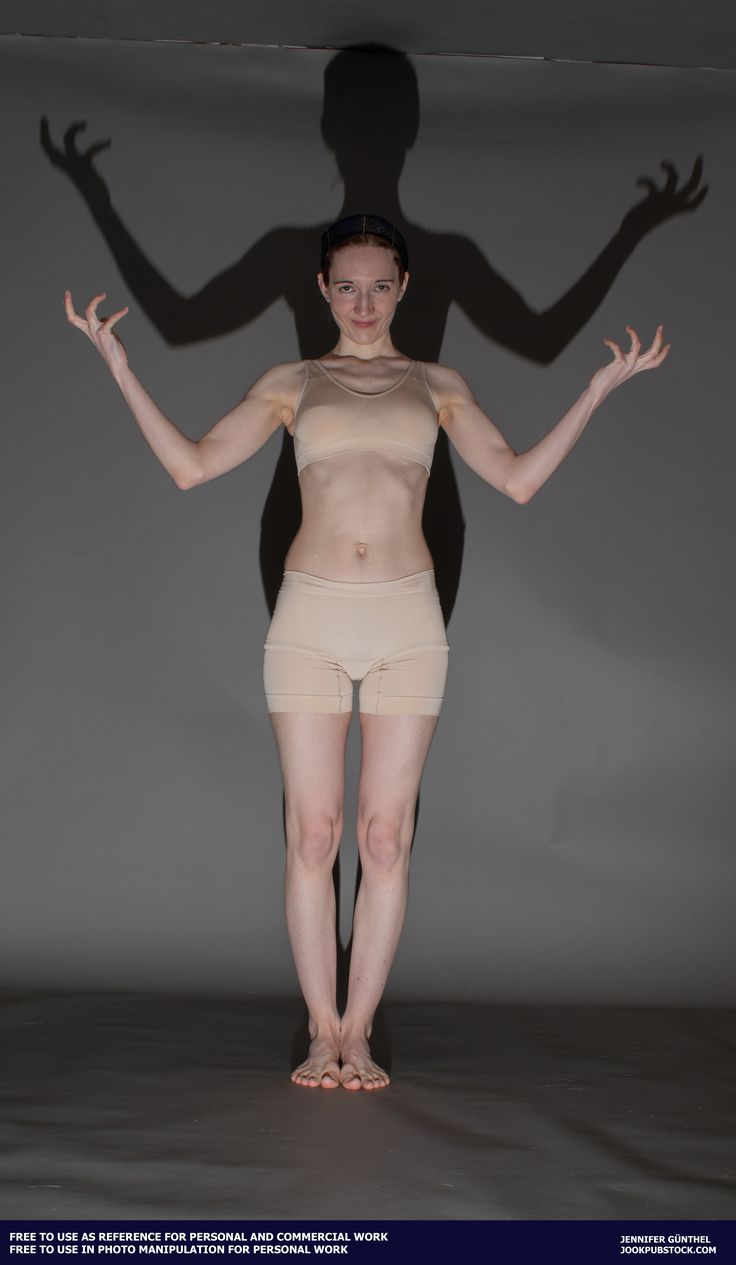 a naked woman standing in front of a gray background