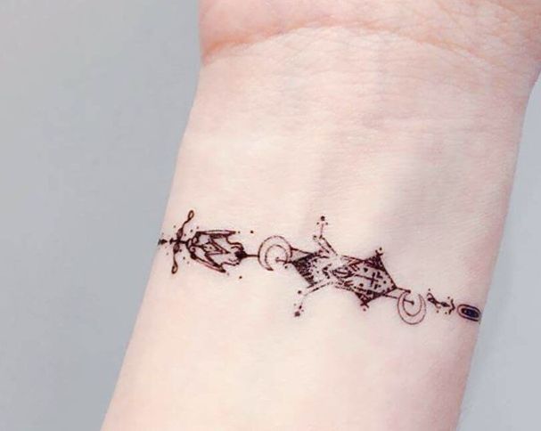 a small tattoo on the wrist of a woman's left arm, which is decorated with black ink