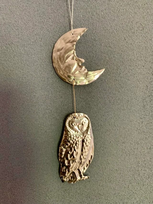 an owl and the moon hanging on a wall