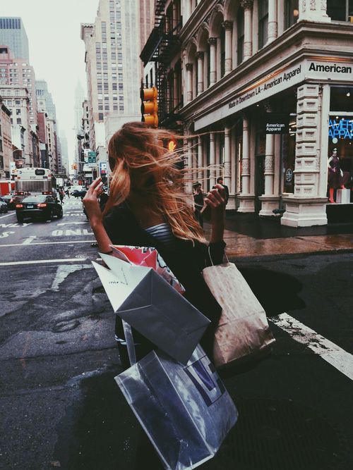 a woman walking down the street carrying shopping bags