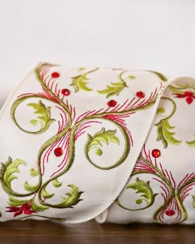 a roll of white ribbon with red and green designs on it, sitting on a table