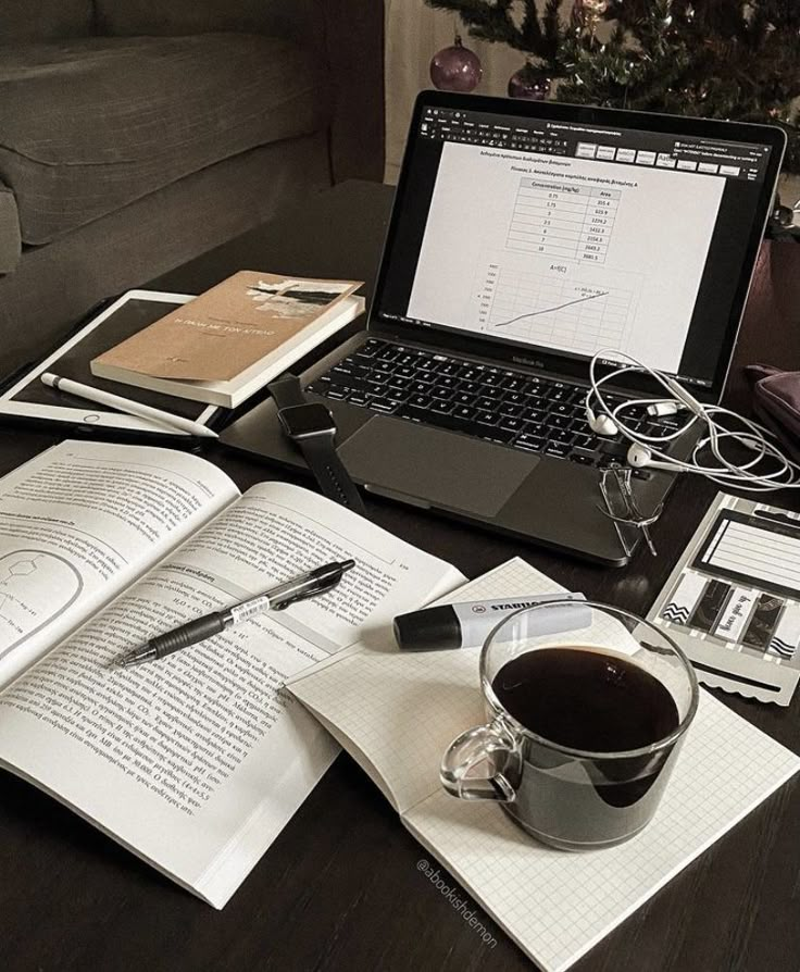 an open laptop computer sitting on top of a desk next to a cup of coffee