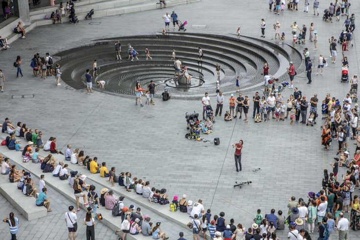 a crowd of people standing around a fountain