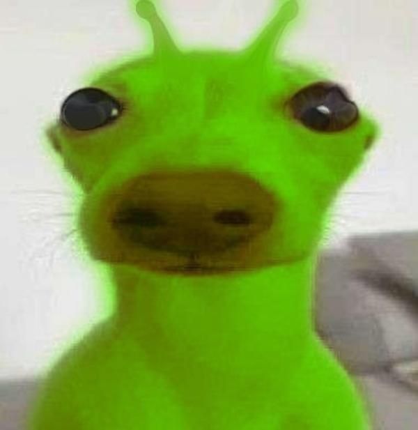 a close up of a green toy with big eyes