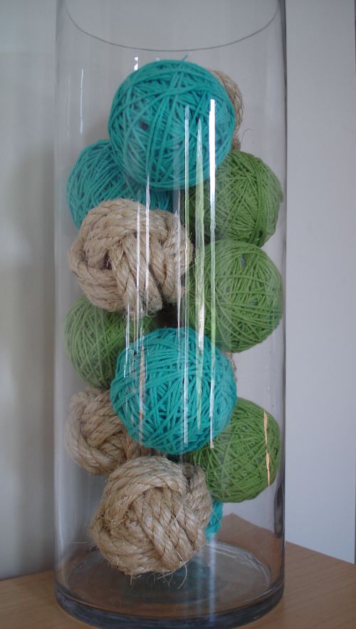 several balls of yarn are in a glass container