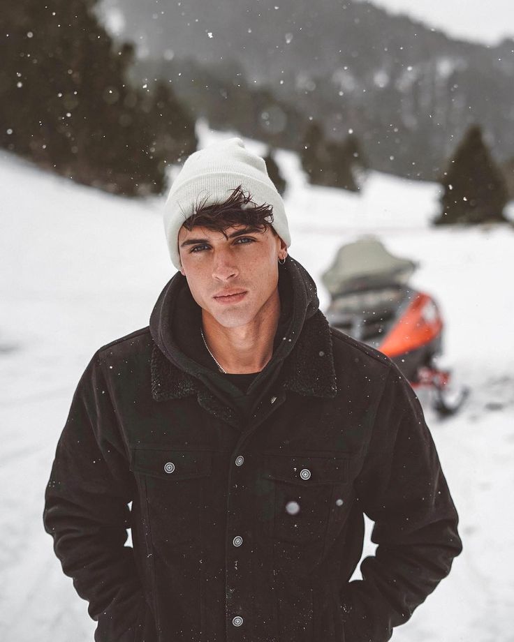 a young man is standing in the snow