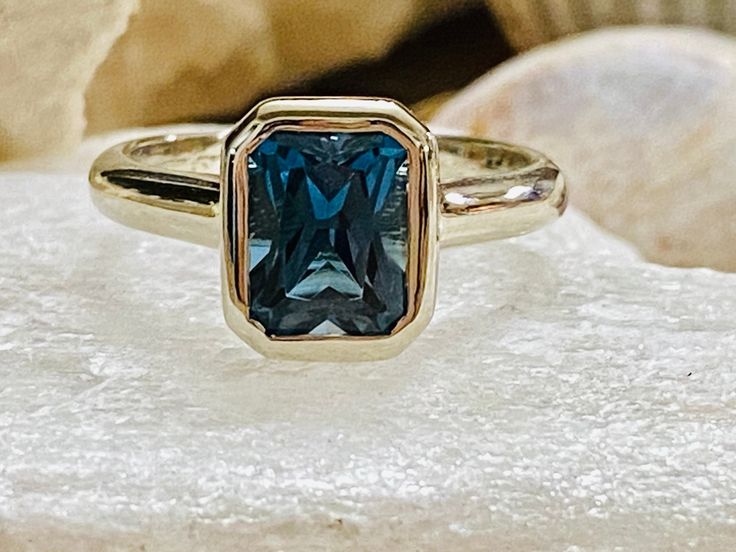 This classic bezel ring contains a 2.00 ct. natural radiant cut London blue topaz. The center stone measures 8x6mm . The ring is available in sterling silver, and 14k white, yellow or rose gold. The mounting is a modern, elegant setting with a high polish finish. Please send me a message if you need a size not listed. This ring can also be customized with any color center stone. All items are handmade by me in my shop in Manalapan, NJ. Please message me with any questions. Shipping within the Un London Blue Topaz Engagement Ring, Engagement Ring Bezel, London Blue Topaz Engagement Rings, Cathedral Engagement Rings, Blue Topaz Engagement Ring, Bling Ring, Bezel Engagement Ring, Moissanite Engagement Ring Solitaire, Ring Bezel