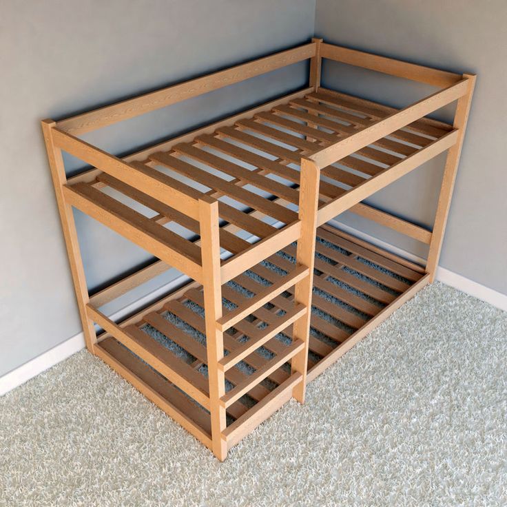 a wooden bunk bed sitting on top of a carpeted floor next to a wall