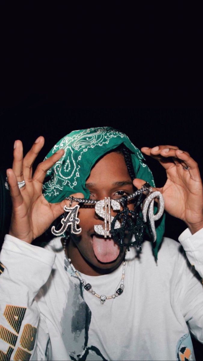 a woman with her mouth open wearing a green bandana and holding up her hands to her face