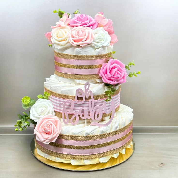 a three tiered cake decorated with pink and white flowers