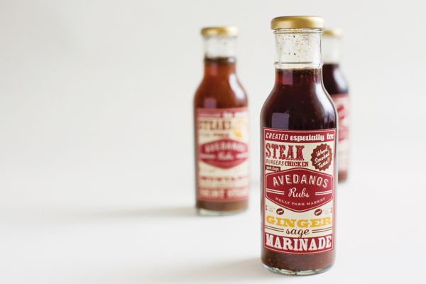 three bottles of hot sauce sitting next to each other on a white surface with one bottle in the foreground