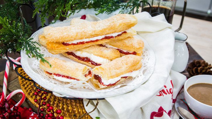 two sandwiches are on a plate next to a cup of coffee and candy canes