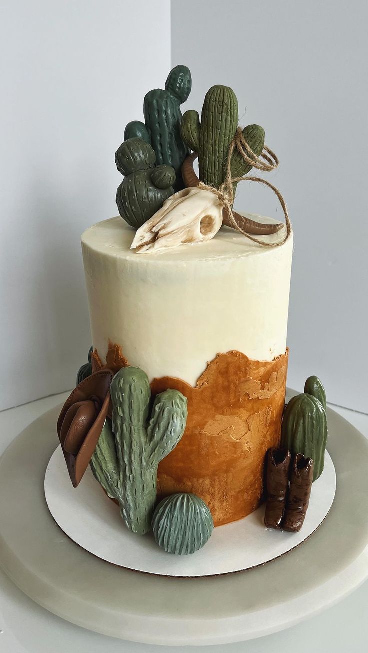 a desert themed cake with cactus decorations on top