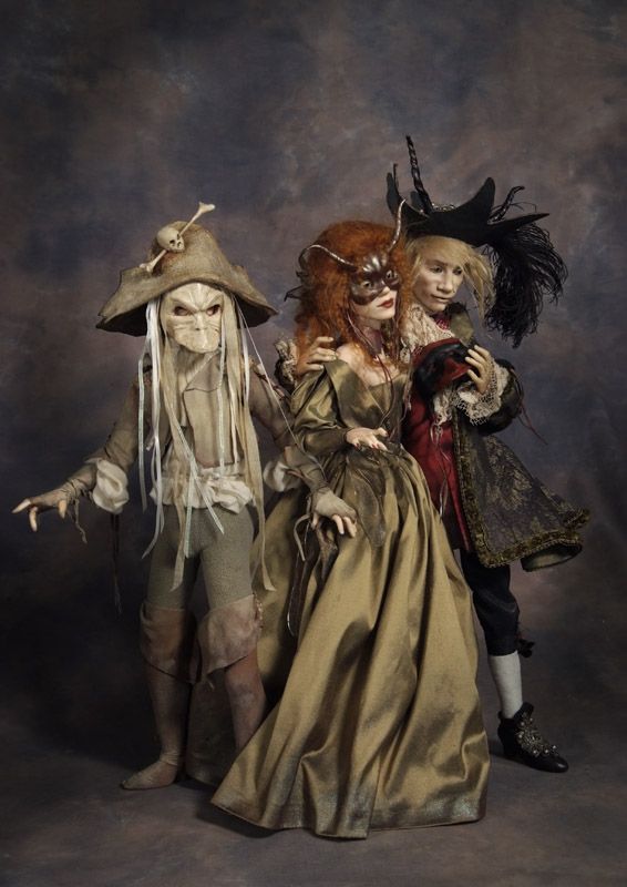 three dolls dressed up in costumes and hats