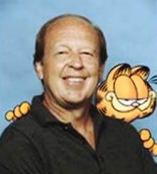 a man with a tiger on his shoulder smiling at the camera while standing in front of a blue background