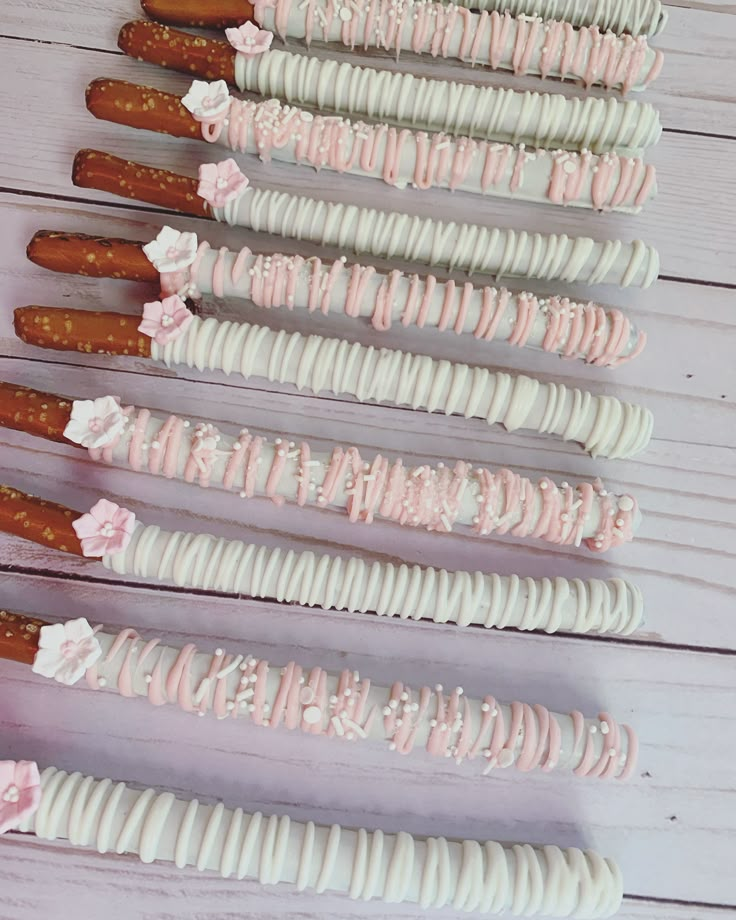 there are many pink and white desserts on sticks