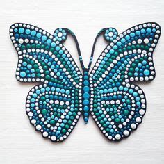 a blue butterfly with white dots on it's wings is sitting on a table