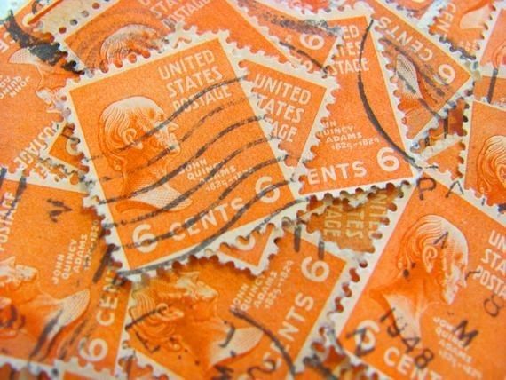 many orange and white stamps are stacked on top of each other