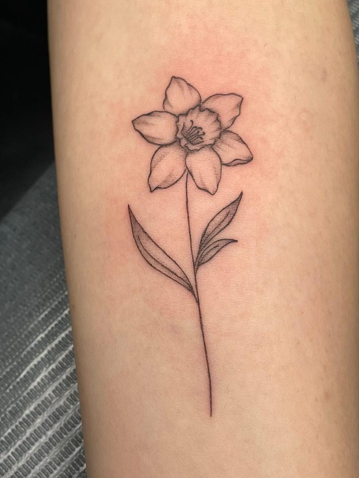 Tattoo ideas female Hand Tattoo | tattoo ideas by  Devon Ray Dainty Daffodil Tattoo With Name, Daffodil Name Stem Tattoo, Daffodil With Bee Tattoo, Lilly And Daffodil Tattoo, Small Dafodill Tattoo, Daffodil Tattoo Birth Flower, Daffodil Tattoo Forearm, Daffodil Simple Tattoo, Tattoo Ideas Female Daffodil