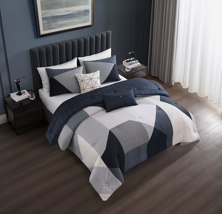 a bed with blue and white comforters in a bedroom