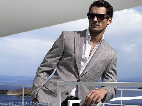 a man in a suit and sunglasses leaning against a railing