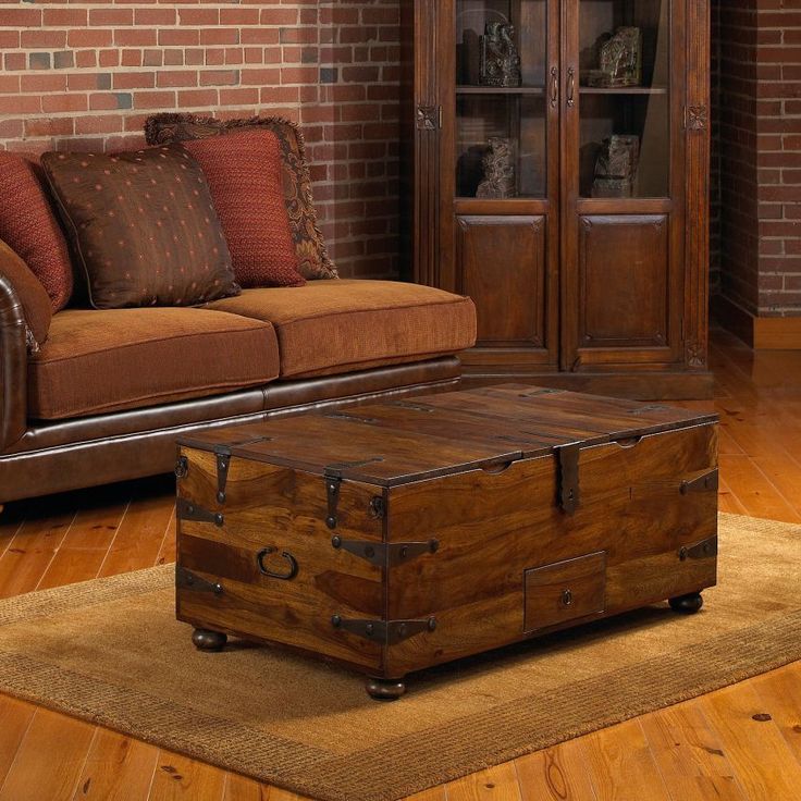 an old trunk is sitting on the floor in front of a couch and coffee table