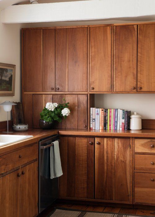 a kitchen with wooden cabinets and white flowers