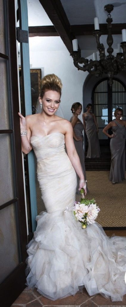 a woman in a wedding dress is posing for the camera