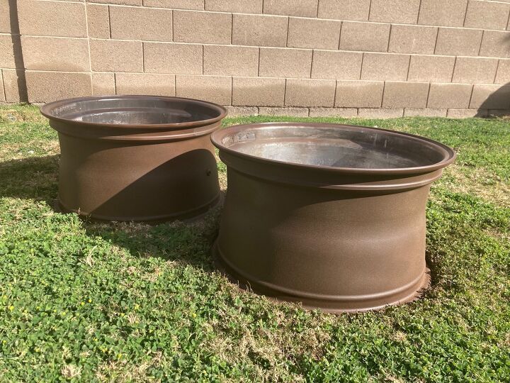 two brown pots sitting in the grass near a brick wall