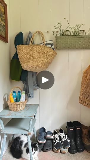 a dog is laying on the floor next to shoes and baskets in a room with white walls