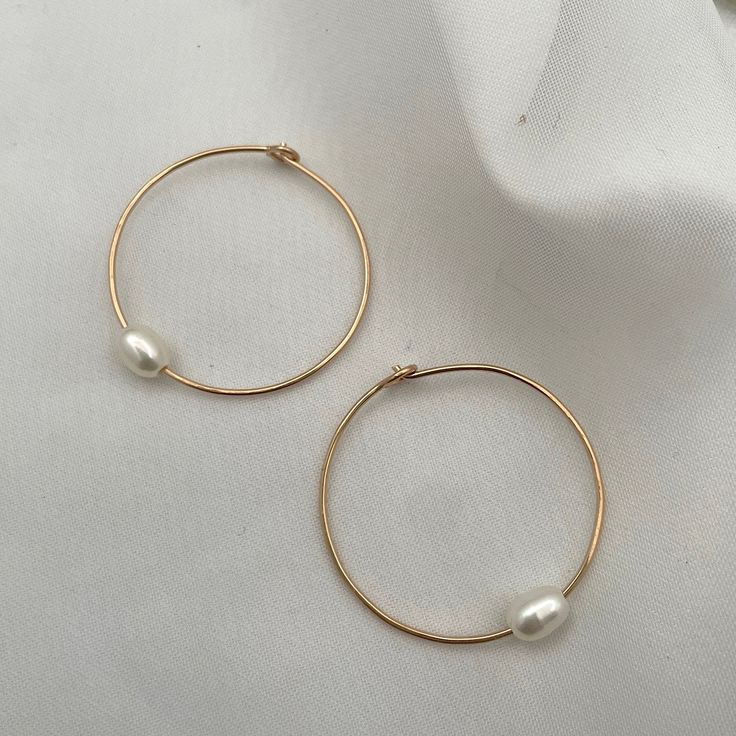 Hand-forged hoops featuring a single freshwater pearl are the perfect everyday accessory. Simple, clean, classic lines you'll never want to take off. Hand-made in our studio. These super lightweight hoop earrings are made of sterling silver or 14kt gold fill wire. Approximately 1 1/4 inch diameter. Minimalist Hoop Pearl Earrings With Ear Wire, Small Pearl Hoop Earrings For Everyday, Sterling Silver Small Hoop Pearl Earrings For Everyday, Minimalist Pearl Charm Hoop Earrings For Everyday, Minimalist Hoop Pearl Charm Jewelry, Minimalist Hoop Jewelry With Pearl Charm, Everyday Small Hoop Sterling Silver Pearl Earrings, Minimalist 14k Gold-filled Hoop Earrings With Pearl Charm, Minimalist Everyday Hoop Earrings With Pearl Charm