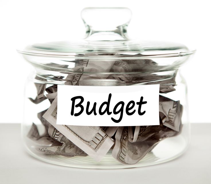 a glass jar filled with money sitting on top of a white table next to a sign that reads college fund