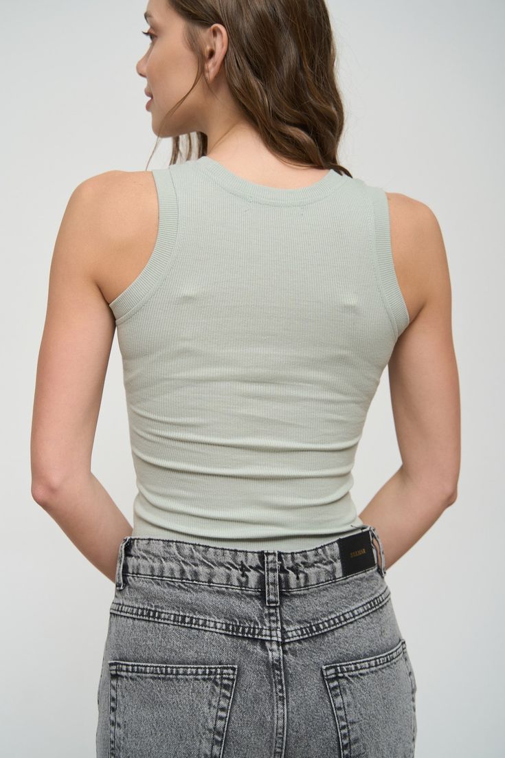 The basic rib-knit tank top is a versatile base for outfits in different styles, including sporty and casual looks. It pairs well with jeans, shorts, joggers, oversized shirts, and denim jackets. Its slim-fit style allows you to look stunning. This item is very comfortable and practical for the summer season, so we recommend buying it several in different colors. Seamless Cotton Top For Spring, Cotton Top With Seamless Construction For Spring, Basic Cotton Tank Top For Summer, Spring Seamless Tops For Layering, Fitted Basic Tank Top For Summer, Casual Solid Seamless Tank Top, Casual Seamless Solid Tank Top, Basic Ribbed Sleeveless Top, Basic Sleeveless Ribbed Top