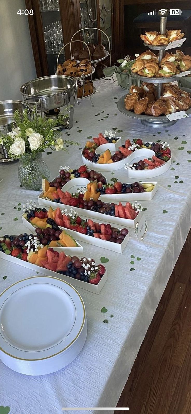 a long table with plates and bowls of food on it, along with other dishes