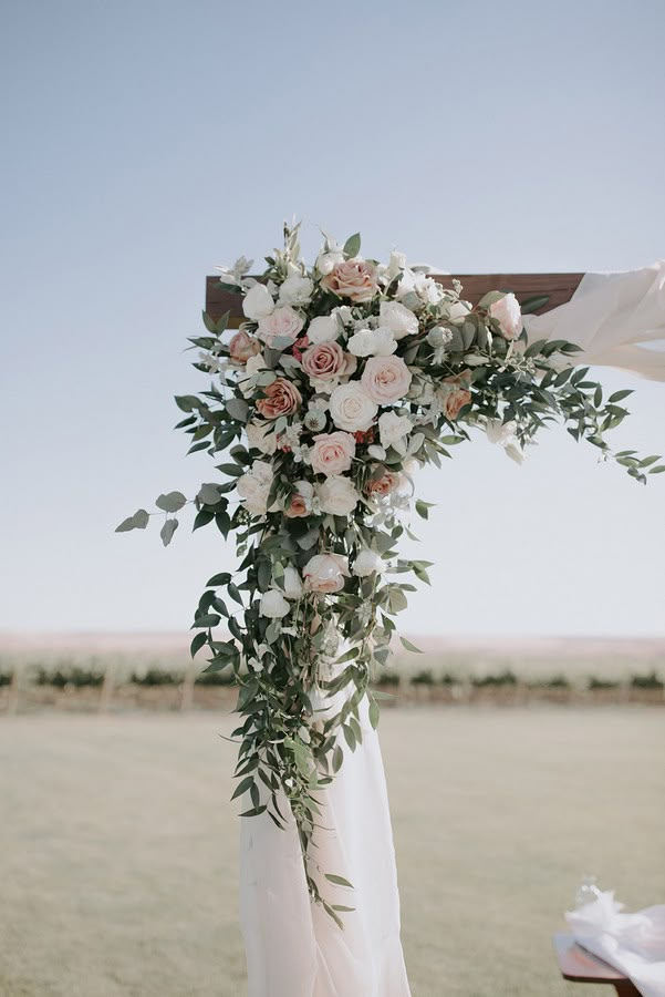 a wedding arch decorated with flowers and greenery