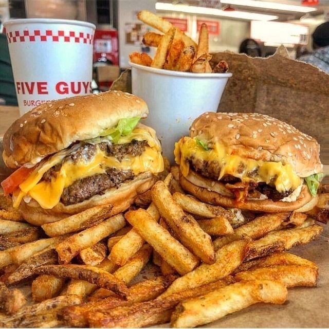 two hamburgers and french fries on a table