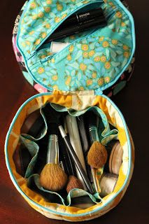 an open makeup bag on a table with brushes and other items in it that are inside