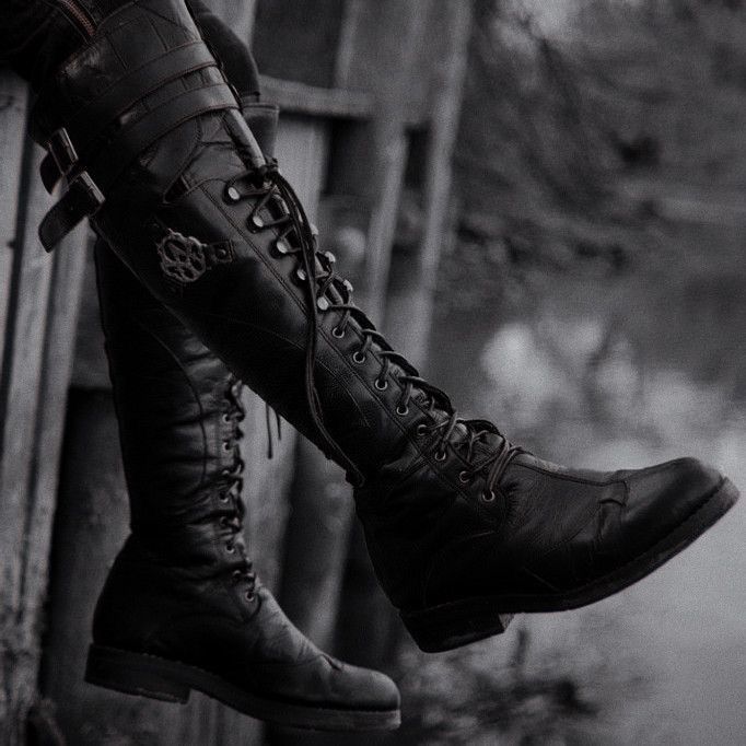 a pair of boots sitting on top of a wooden bench