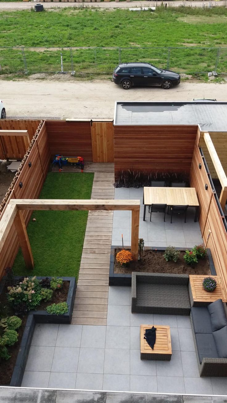 an overhead view of a backyard with wooden furniture and green grass in the back yard