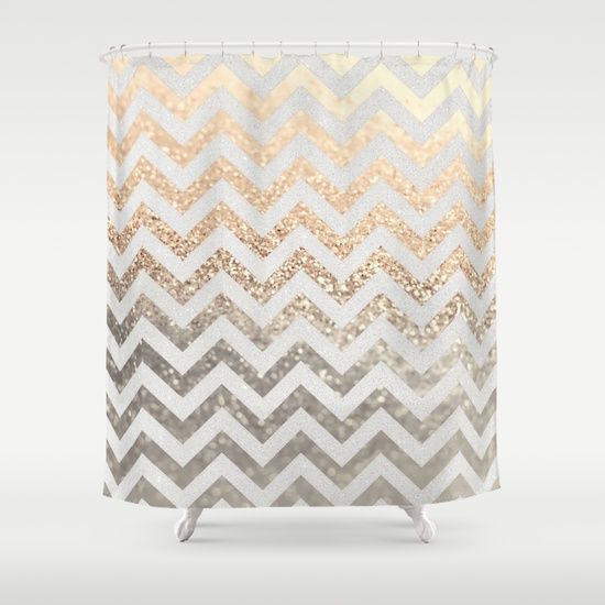 a shower curtain with gold and silver chevrons on the bottom, in front of a white background