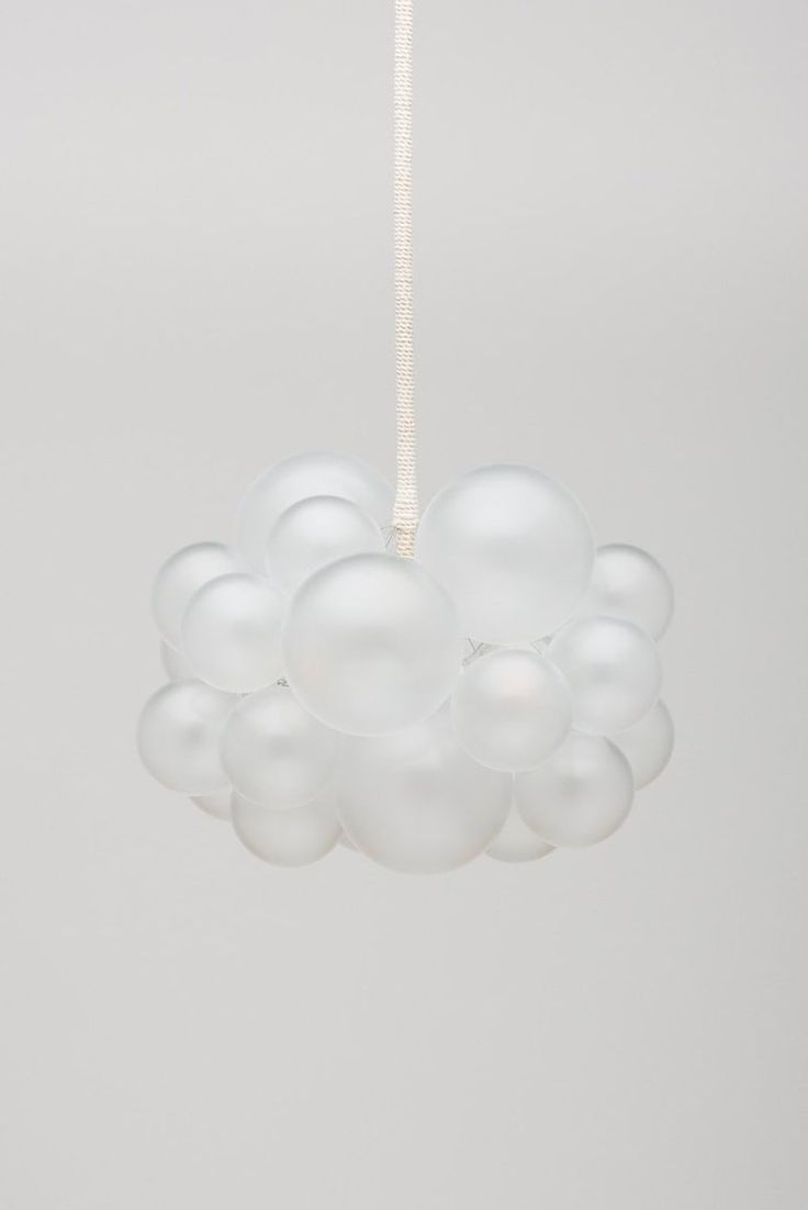 a white chandelier hanging from a ceiling with many balloons attached to the chain