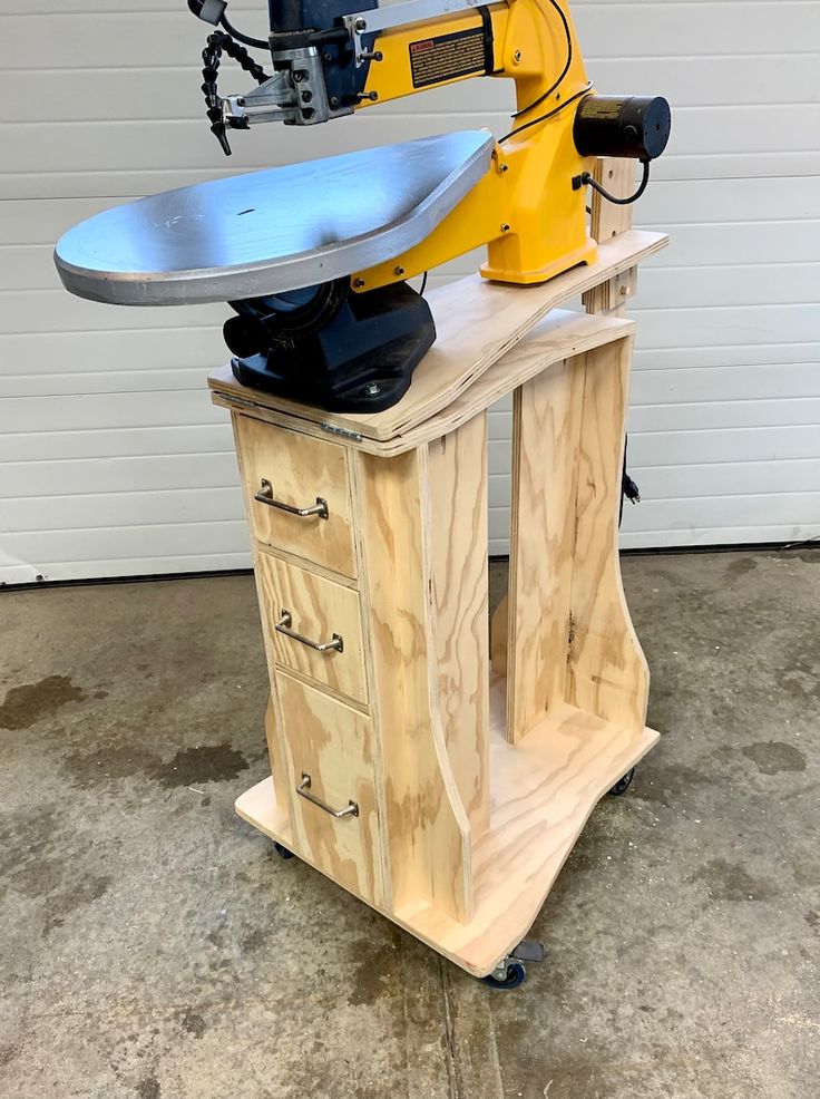 a machine that is sitting on top of a wooden table in front of a garage door